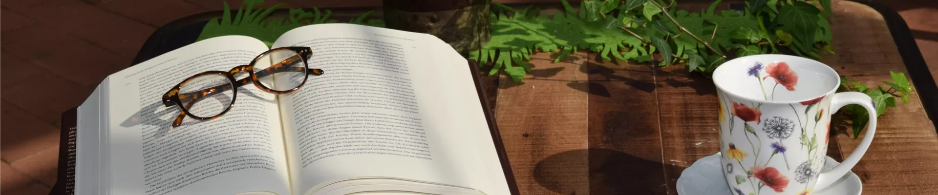 Buch mit Brille und Tasse